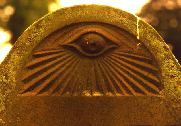 A historical stone monument showcasing the eye of providence and masonic symbols in classical architecture.